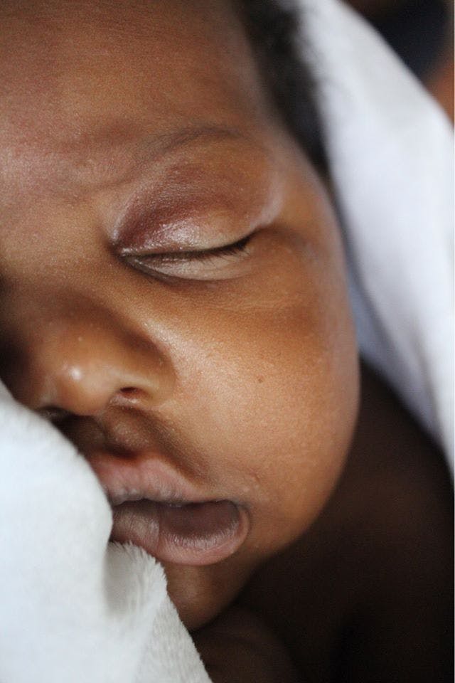 A serene close-up of a baby sleeping, showcasing innocence and tranquility.